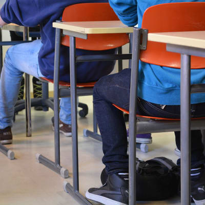 Elever sitter vid sina bord i klassrummet.