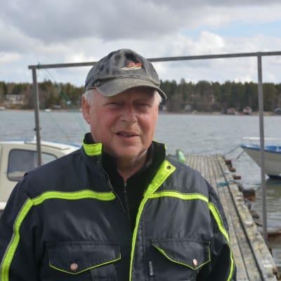Man i keps i småbåtshamn