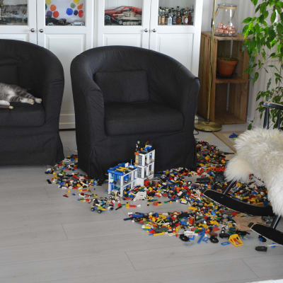 Katt sover i stol bland leksaker.