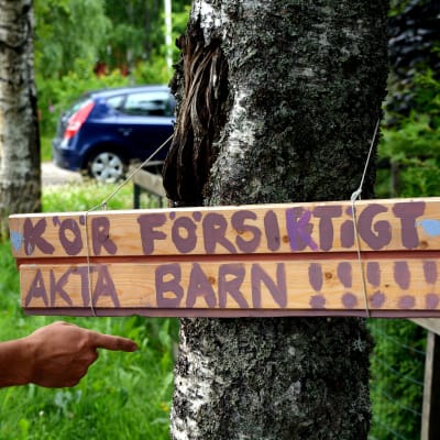 Hemmasnickrad vägskylt hänger på ett träd. 