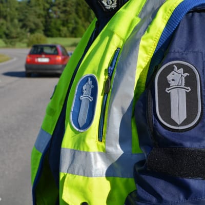 Polis står intill väg.