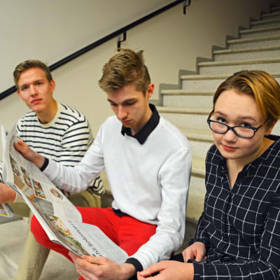 Gymnasieeleverna Fabian Tillander, Kristofer Söderström och Pinja Karlqvist läser tidningen Östnyland