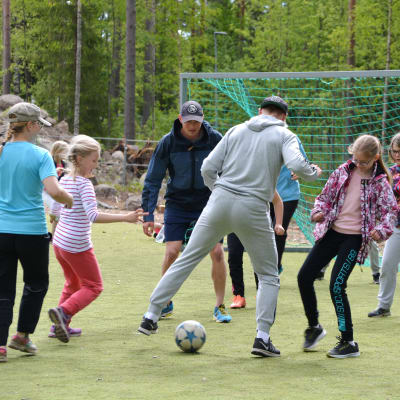 Richard och Fredrik Jensen spelar fotboll med Vårberga skolas elever.