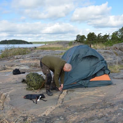 Patrik Berghäll sätter upp ett tält