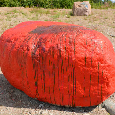 Klottad rödmålad sten i Pyttis.