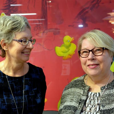 två kvinnor framför en tavla