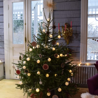 Julgran med lampor och paffdekorationer med trådornament