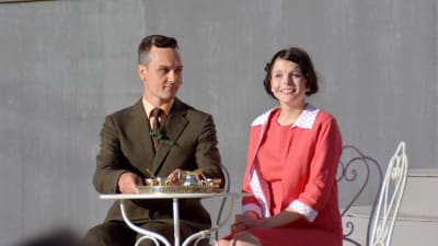 Leif Wadenström i rollen som kapten von Trapp sitter vid ett bord tillsammans med baronessan Elsa Schraeder (Jennifer Karlsson).