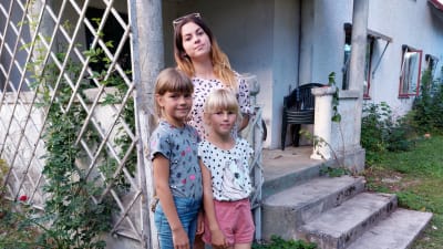 Tre ukrainska systrar står invid trappan till sitt nya hem på Gotland