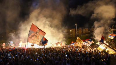 Människor demonstrerar och viftar med Serviens flaggor.