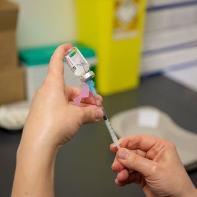 Astra Zeneca -rokotetta valmistava sairaanhoitaja Porvoon rokotuskeskuksessa. 18.3.2021.
