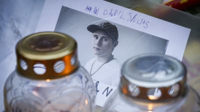 Valokuva Einárista, jonka edessä on kaksi hautakynttilää. 