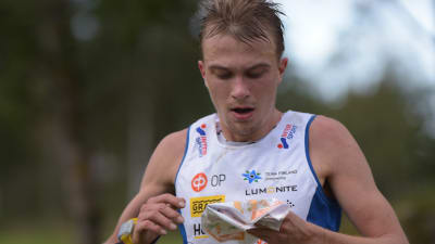 Miika Kurmula springer och tittar på kartan.