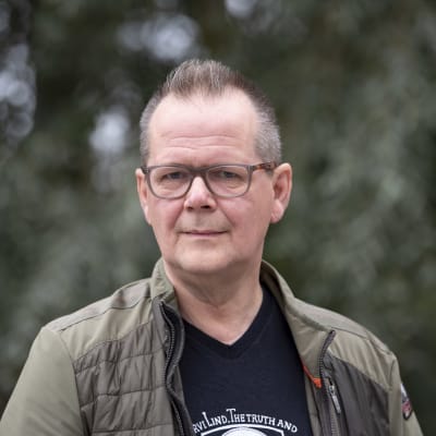 Kirjailija Kari Hotakainen hopeapajun edessä.