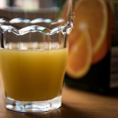 ett glas med gul saft