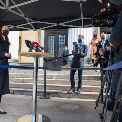 Statsminister Marin i helfigur möter pressen utanför Ständerhuset.