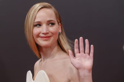 Skådespelare Jennifer Lawrence vinkar till fotografer.