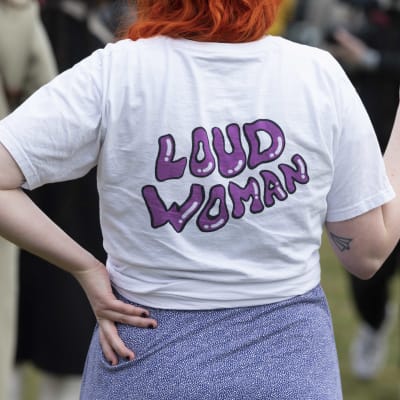 Nainen on pukeutunut paitaan, jossa lukee Loud woman.