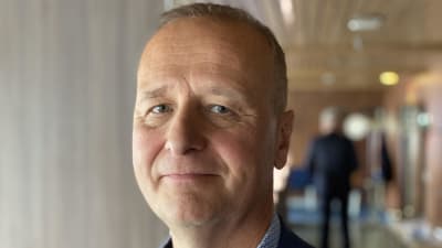 Äldre rund man i kostym. 