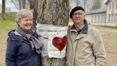 En kvinna och en man står vid ett gammalt träd.