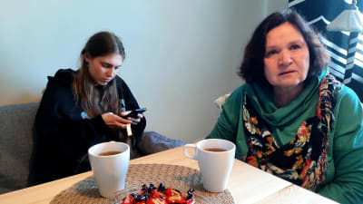 Två kvinnor vid kaffebord. 