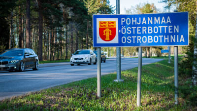 Ett trafikmärke för landskapet Österbotten, invid en trafikerad asfaltväg