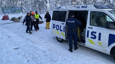 Poliser för en person in i en polisbil.