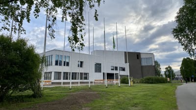 Rovaniemen kaupungintalo, edustalla lipputankoja ja vihreää nurmikkoa. 