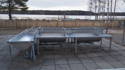 Plats för mattvätt på land vid en sjöstrand. 