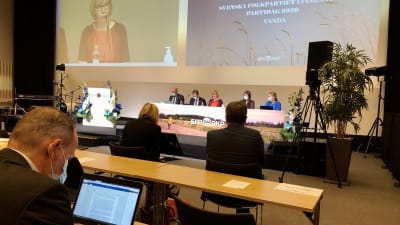 Personer sitter vid bord på SFP:s partidag i Vanda den 26 september 2020.