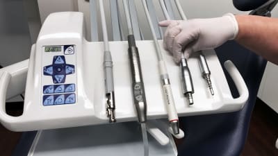 Fem olika instrument, bland annat skaften till borrar, på en bricka hos tandläkaren. 