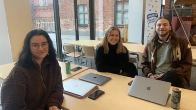 Tre stycken studerande sitter vid ett bord i Academill i Vasa. 