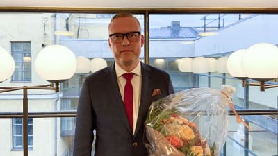 Jukka-Pekka Ujula står med en blombukett i famnen efter att precis ha blivit utnämnd till kanslichef.