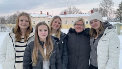 Fyra tjejer och Hangö svenska församlings ungdomsledare utanför ungdomslokalen 27:an.