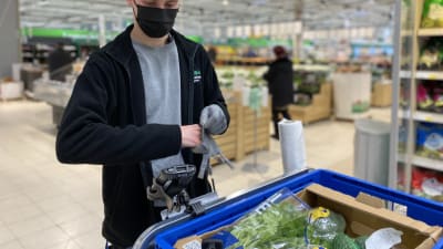 Anställd i butik plockar ihop en varukorg som beställts på nätet.