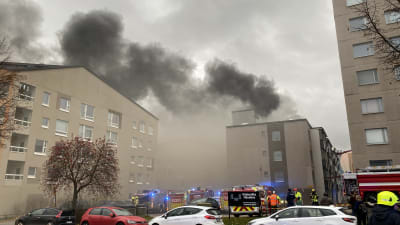 Rykande höghus och räddningspersonal.
