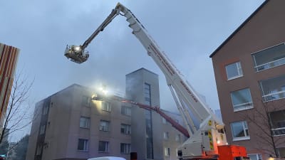 Två lyftkranar vid ett höghus.