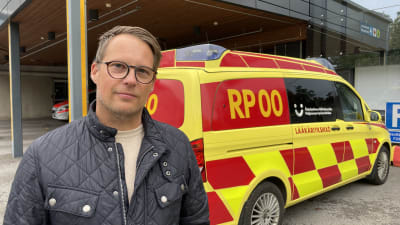 En man framför en läkarbil.
