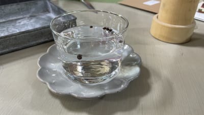 Ett glas med vatten och några svarta små frön i blöt.
