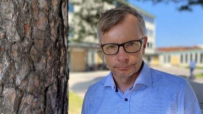 Heikki Hiilamo, forskningsprofessor vid THL, bredvid ett träd utanför jobbet. 