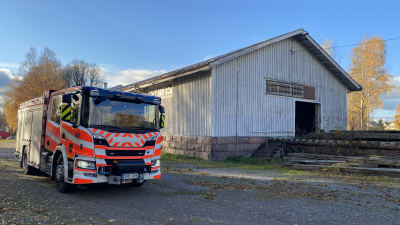 En brandbil framför en byggnad. 