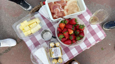 Picnicbord med choclad, jordgubbar, ananas och annat.