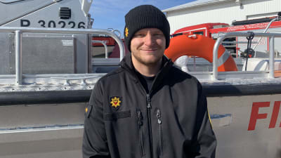 Johan Sandell, brandmästare vid Österbottens räddningsverk står framför en plåtbåt. 