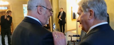 Finlands president Sauli Niinistö lägger en vänskaplig hand på Estlands president Alar Karis axel.