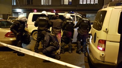 Demonstrant förs till polisbil av flera poliser.