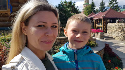 En blond tatarisk kvinna med sin son fotograferade i närbild.