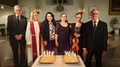 Medverkande i TV-gudstjänsten Andakt och bön på Alla Helgons dag. Fr.v. Erik Vikström, Hanna Eisentraut-Söderström, Brenda Serralde, Camilla Wiksten-Rönnbacka, Elina Mieskolainen, Mikael Helenelund som står framför altaret i Borgå kyrka.