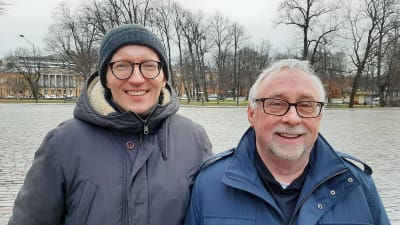 Christopher Skutela och Stephen Person, två glada män med glasögon turistar i Åbo, med Åbo Akademis huvudbyggnad i bakgrunden.