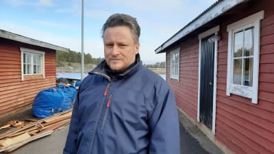 Man vid sjöbodar