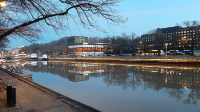 Åbo stadsteater och statens ämbetshus speglas i Aura å.